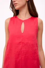 Vestido corto sin mangas color marrón chocolate, con corte holgado tipo babydoll y un pequeño ojal en el centro del escote redondo. El ruedo tiene un volante sutil.