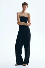 Pantalón sastrero de corte holgado color negro, con cintura clásica, cierre con botón y trabillas para cinturón. Cuenta con piernas rectas, pinzas, bolsillos al bies y raya marcada adelante y atrás.
