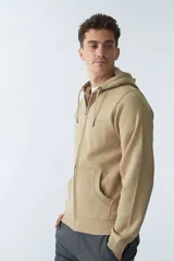 Campera de felpa color blanco hueso, con capucha y cordón ajustable, cierre frontal con cremallera, bolsillos laterales, logo y arte estampado en el pecho.