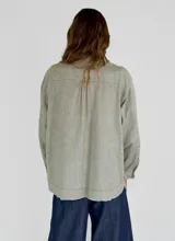 Camisa color beige con cuello mao, mangas largas abullonadas y cierre frontal con botones.