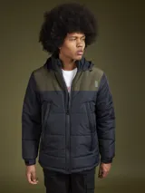 Campera acolchada con diseño de bloques de color en azul marino y azul oscuro, con capucha, cierre frontal y bolsillos laterales.