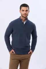 Buzo tejido texturado color verde oscuro, con cuello alto y cierre parcial de tres botones. Tiene mangas largas y un pequeño detalle de etiqueta marrón en el dobladillo inferior.