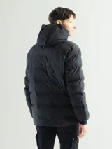 Campera puffer negra con capucha integrada y cordones de ajuste. Presenta diseño capitoneado, cierre frontal, bolsillos laterales con cierre y puños elásticos.