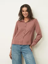 Camisa de manga larga con cuello clásico y cierre frontal de botones, confeccionada en tela con acabado satinado.
