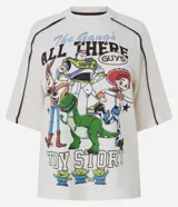 Remera de algodón color crema con cuello redondo y mangas cortas con costuras desplazadas en contraste. Presenta un estampado frontal grande con los personajes de la película Toy Story.