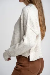 Sweater de punto con diseño jaspeado multicolor, cuello redondo y corte oversize. Presenta mangas largas con puños acanalados y un diseño de tejido acanalado vertical.