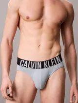 Pack de tres slips Calvin Klein de talle medio con cinturilla elástica distintiva de la marca. Incluye uno de color gris, uno negro y uno celeste.