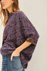 Camisa de algodón con estampado floral en tonos azul y rojo, corte amplio y mangas 3/4 con detalle bordado en los puños.