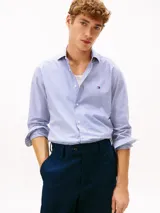 Camisa de Tommy Hilfiger confeccionada en popelín de algodón regenerativo, con diseño de rayas bengal en color celeste y blanco, manga larga y logo bordado en el pecho.