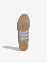 Zapatillas Adidas Taekwondo Mei Elite de diseño estilizado en color plateado metalizado, con sistema de amarre asimétrico, costuras decorativas en la punta y suela de goma color caramelo.