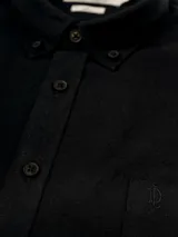Camisa negra de lino con corte clásico, cuello abotonado y bolsillo en el pecho.
