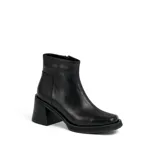 Bota corta de cuero negro con plataforma y taco cuadrado. Presenta un diseño de textura acanalada en la parte posterior del talón y cierre lateral.