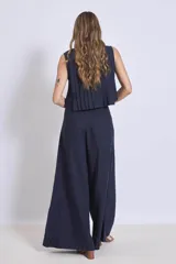 Blusa sin mangas color azul marino, con cuello redondo y detalle de tablas verticales en el frente. Corte holgado y corto.