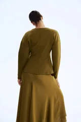 Top de manga larga color verde oliva, con escote en V profundo y paneles laterales que entallan la cintura, creando un efecto peplum sutil.