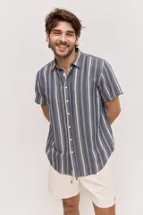Camisa de manga corta color azul con diseño a rayas verticales, cuello clásico y cierre frontal de botones.