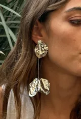 Aros colgantes dorados con dos piezas irregulares con textura.