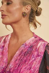 Aros tipo botón con diseño de flor, elaborados con pedrería facetada multicolor de efecto iridiscente.
