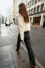 Jeans tobilleros de tiro alto, color negro lavado, con pernera recta y acabado sin costura en el ruedo. Modelo de cinco bolsillos con cierre frontal de cremallera y botón.