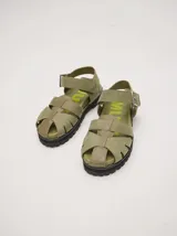 Sandalias tipo romanas de cuero vacuno color beige, con diseño de tiras entrelazadas, hebilla metálica lateral y plataforma de goma dentada.