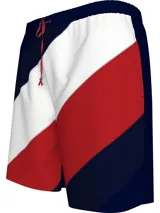 Short de baño con diseño de bloques de color diagonales en azul marino, blanco y rojo. Cintura elástica con cordón de ajuste rojo, bolsillos laterales y bolsillo trasero con cierre de velcro.