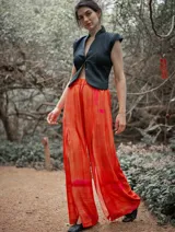 Mono de vestir verde esmeralda con estampado abstracto, escote en V, mangas cortas y pantalón palazzo con aberturas laterales.