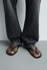 Sandalia de goma color negro, de diseño plano y tiras delgadas en el empeine estilo ojota.