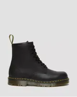 Botas de caña alta Dr. Martens modelo 1460, color negro, confeccionadas en cuero de plena flor con diseño de ocho ojales, cordones negros y suela gruesa con costuras amarillas características de la marca.