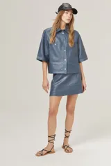 Minifalda de cuero azul con cintura alta, corte en línea A, cierre metálico lateral y bolsillos traseros.