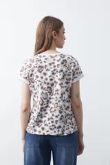 Remera de manga corta con estampado animal print en tonos blanco, marrón, beige y celeste.