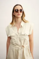 Vestido camisero corto negro con cuello clásico, solapas, cierre frontal con botones, cinturón de lazo y bolsillos laterales.