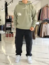 Canguro oversize gris con capucha y gran estampado gráfico trasero en tono más oscuro.