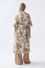 Kimono largo color crudo con estampado de hojas color camel, mangas tres cuartos y cinto para atar en la cintura.