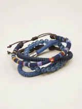 Set de pulseras elásticas con cuentas de vidrio azules y pulseras de cordón trenzado azul y marrón con detalles de tela estampada.