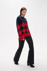 Sweater de tejido jacquard con diseño de rombos en colores azul marino y rojo, de corte holgado, manga larga y cuello redondo.