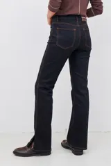 Pantalón tipo jean de corte recto y tiro medio, color burdeos, con costuras a tono y abertura lateral en el ruedo.