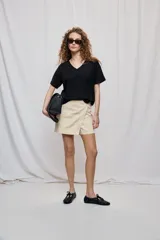 Short cruzado de tiro medio con diseño frontal tipo falda, color negro, de líneas simples y calce cómodo.