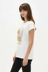 Remera de algodón color beige, de cuello redondo y manga corta con vuelta fija. Presenta un estampado frontal con la leyenda 'Fruit of The Soul' y un diseño de frutillas con un moño verde.