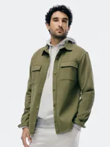 Buzo con capucha de corte clásico, confeccionado en tejido de algodón, con bolsillo frontal tipo canguro y puños acanalados.