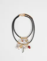 Collar de doble cordón negro con múltiples dijes colgantes en tonos dorados y plateados, incluyendo formas de corazón, alas, piedras y elementos decorativos variados.