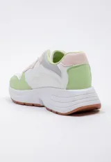 Zapatillas blancas de símil cuero acordonadas con cortes irregulares y pequeños detalles iridiscentes. Su plataforma es irregular y cuenta con 5 cm de alto.