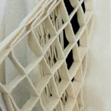 Capa azul de lana merino afieltrada, con guarda tejida en cuello y ruedo. Se puede usar como poncho o como capa abierta.