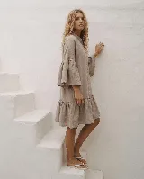Vestido corto de lino color celeste, con cuello mao, cierre frontal abotonado con botones de nácar, mangas tres cuartos acampanadas con volados y falda con volante en el dobladillo.