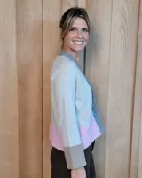 Cardigan de lana lambswool con diseño color block en tonos beige, marrón y turquesa. Presenta escote en V, cierre frontal con botones y puños anchos acanalados.