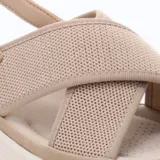 Sandalias de mujer color beige con plataforma blanca. Presentan tiras anchas cruzadas en el empeine, una de ellas de tejido de punto. Cuentan con tira ajustable en el talón.