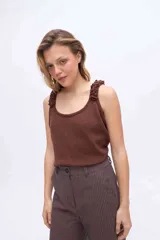 Musculosa de punto azul marino con brillo de lurex, escote redondo y breteles anchos decorados con rulos tejidos.