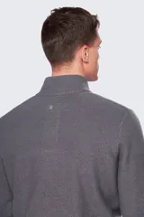 Buzo gris de tejido grueso con cuello alto y medio cierre con botones.