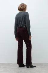 Pantalón de pana de corte recto y tiro medio, color ciruela, con detalle de tajo en el ruedo.