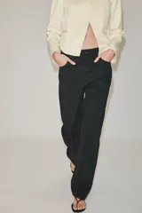Jeans de tiro medio color negro, de corte recto y largo completo, con diseño clásico de cinco bolsillos, trabillas para cinto y cierre frontal con cremallera y botón.