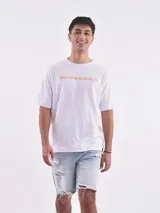 Remera blanca de corte holgado con la frase "The Good Old Days" estampada en color naranja.