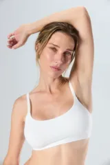 Top deportivo blanco con tirantes ajustables y diseño sin costuras.